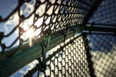 Low angle view of chainlink fence against sky