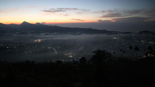 High angle view of silhouette city against sky during sunset