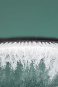 Close-up of glass over water against white background