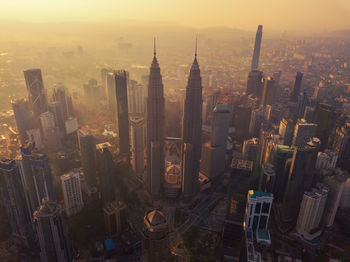 Aerial view of buildings in city during sunset