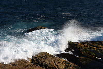 Scenic view of waves breaking on rocks