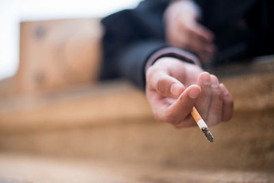 Close-up of human hand holding cigarette
