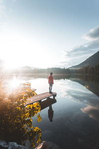 Man standing by lake against sky