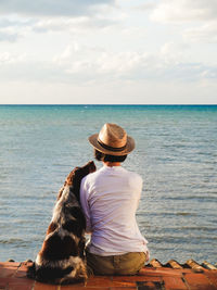 Rear view of woman looking at sea against sky