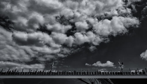 Low angle view of bridge against cloudy sky