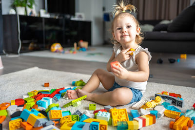 Cute girl playing with multi colored toy at home