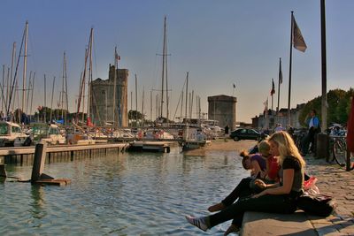 Boats moored at harbor against sky