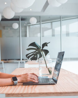 Midsection of person using laptop on table