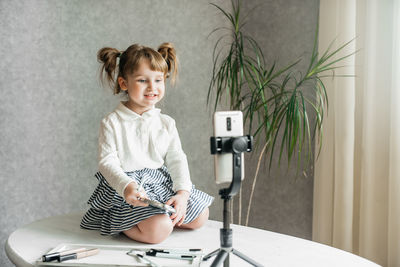 Portrait of cute boy sitting on table