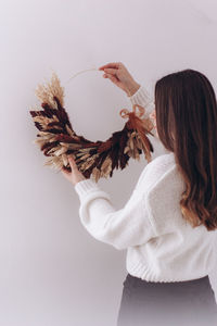 Rear view of woman standing against white background