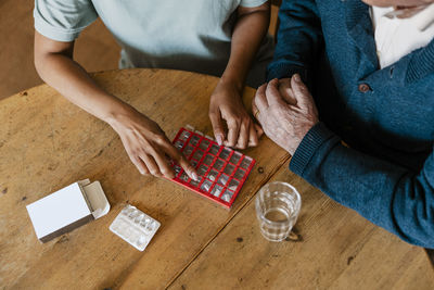 High angle view of healthcare worker explaining dosage to senior man at home