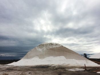 Heap of salt against cloudy sky