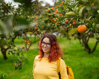 Portrait of a smiling young woman against plants