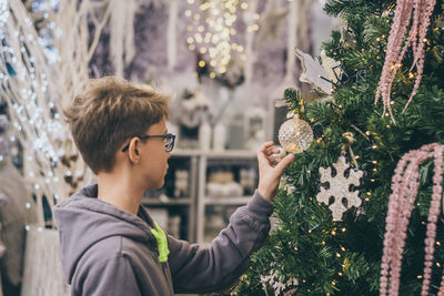 Portrait of man holding christmas tree during winter