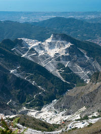 View of the carrara marble quarries and the transport trails carved into the side of the mountain.