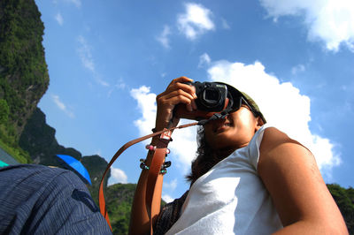 Portrait of man photographing against sky