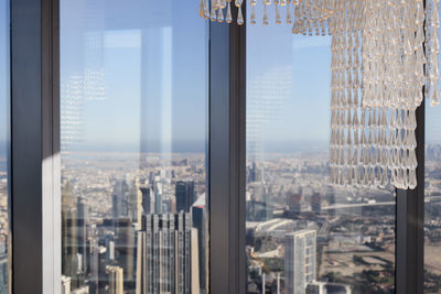 Cityscape against sky seen through glass window