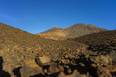 Scenic view of mountains against clear blue sky