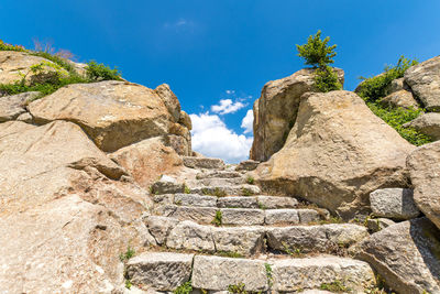 Low angle view of rocks against blue sky