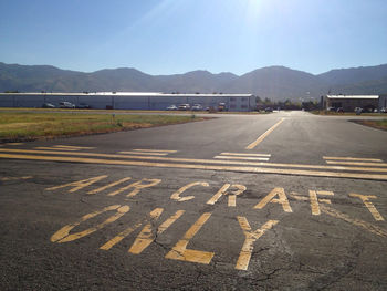 Road by mountains against clear sky