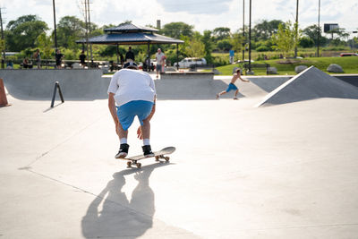 Rear view of man skateboarding on skateboard