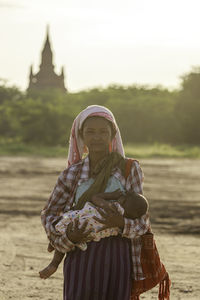 Midsection of woman standing on land against sky