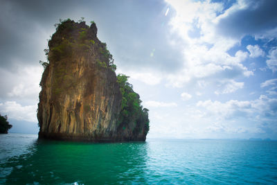 Rock formation in sea against sky