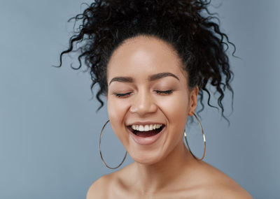 Close-up of young woman against blue background