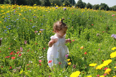 Girl with flowers on field