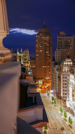 Illuminated buildings in city against sky at night