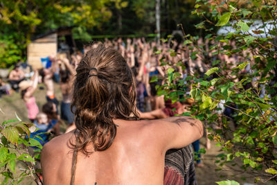 Rear view of a woman with arms raised in background