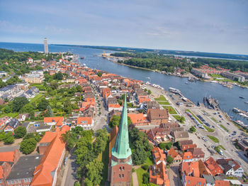 High angle view of townscape by sea against sky