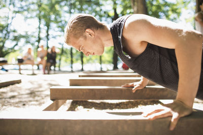 Side view of man doing push-ups at outdoor gym