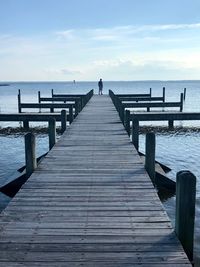 Wooden pier over sea against sky