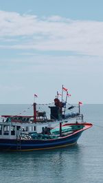 Boats with indonesian flag in sea against sky