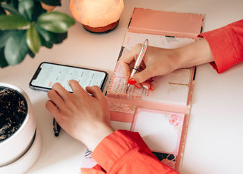High angle view of woman using smart phone on table