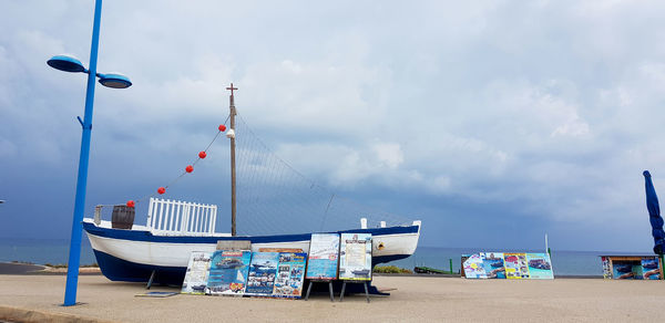 Sailboats on beach against sky