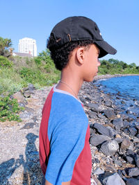Side view of man standing against blue sky