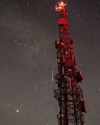 Low angle view of communications tower against sky at night