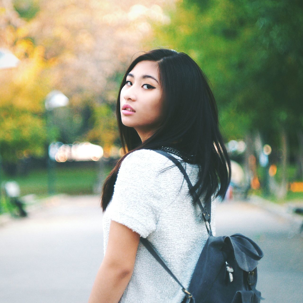 young adult, young women, lifestyles, focus on foreground, person, long hair, casual clothing, leisure activity, front view, portrait, looking at camera, standing, waist up, street, smiling, road