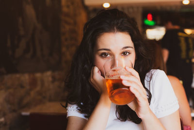 Portrait of a young woman drinking glass