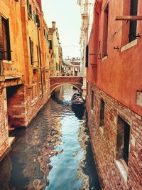 Canal amidst buildings against sky