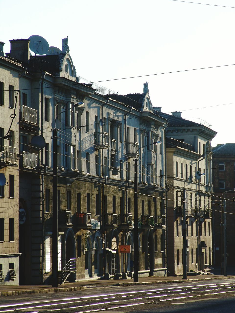 architecture, building exterior, built structure, clear sky, street, city, building, the way forward, residential building, residential structure, road, sky, outdoors, house, day, street light, no people, transportation, incidental people, diminishing perspective