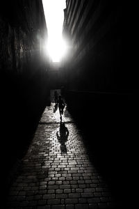 Man walking on footpath amidst street in city