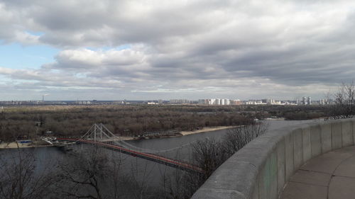 Bridge over river in city against sky