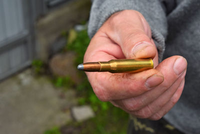 Close-up of human hand holding bullet