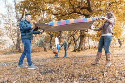 Side view of a couple standing against trees