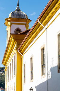 Low angle view of yellow building against sky