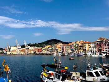 Sailboats moored in harbor by buildings in city