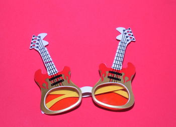 Close-up of guitar eyeglasses over pink background